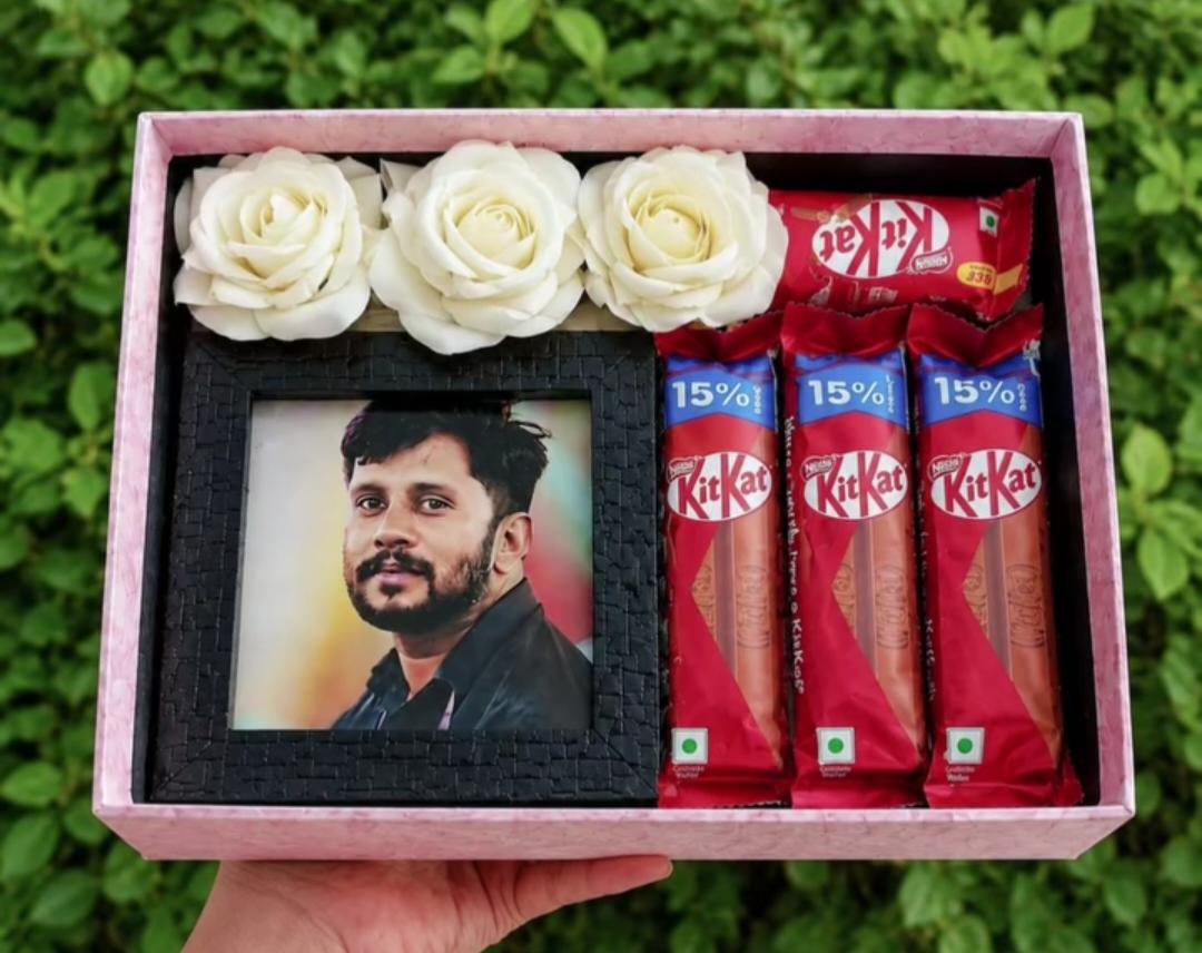 A personal photo, ivory roses, and chocolates in a pink gift box